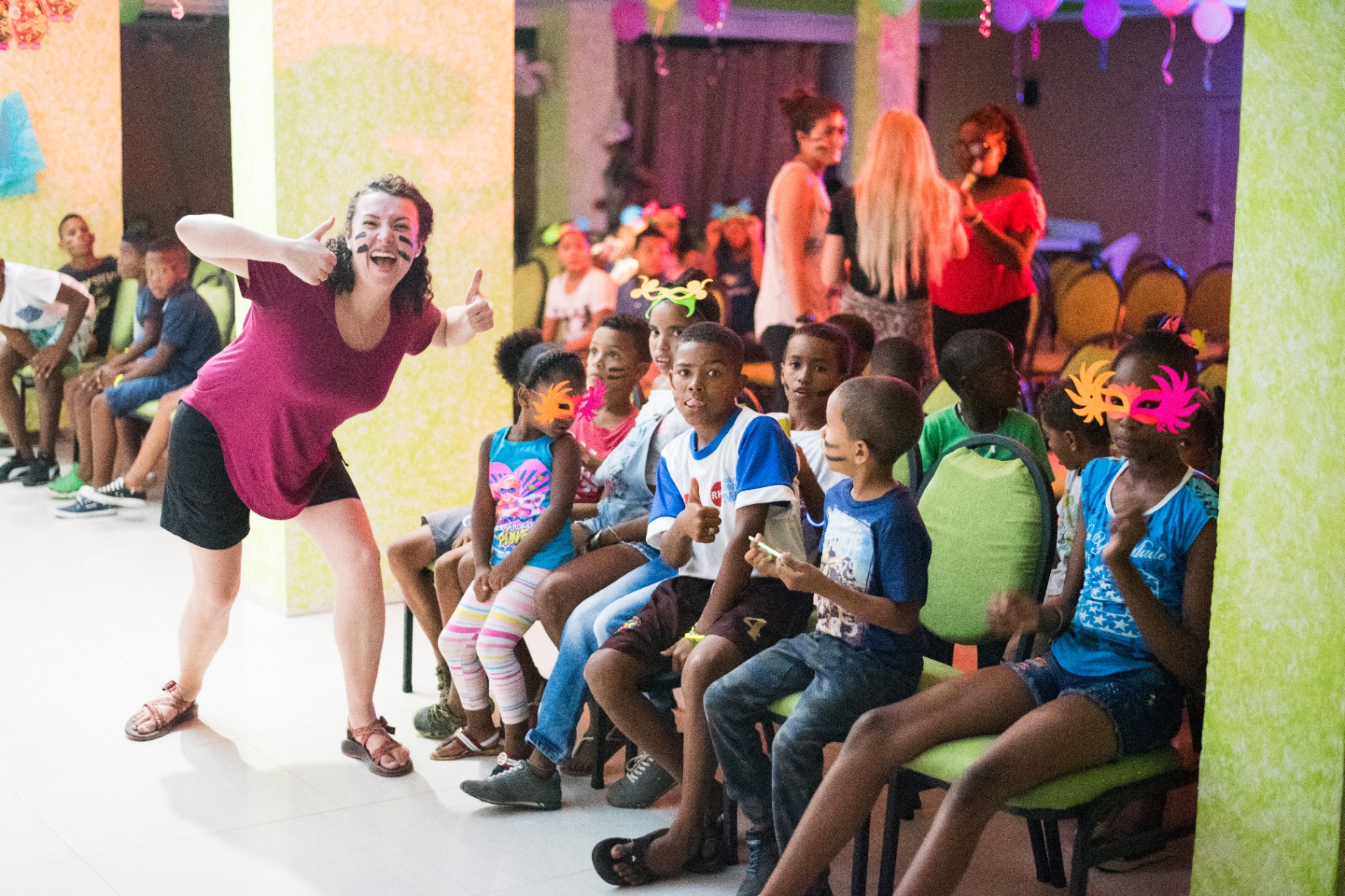 Volunteer celebrating with children at a Colombia community event