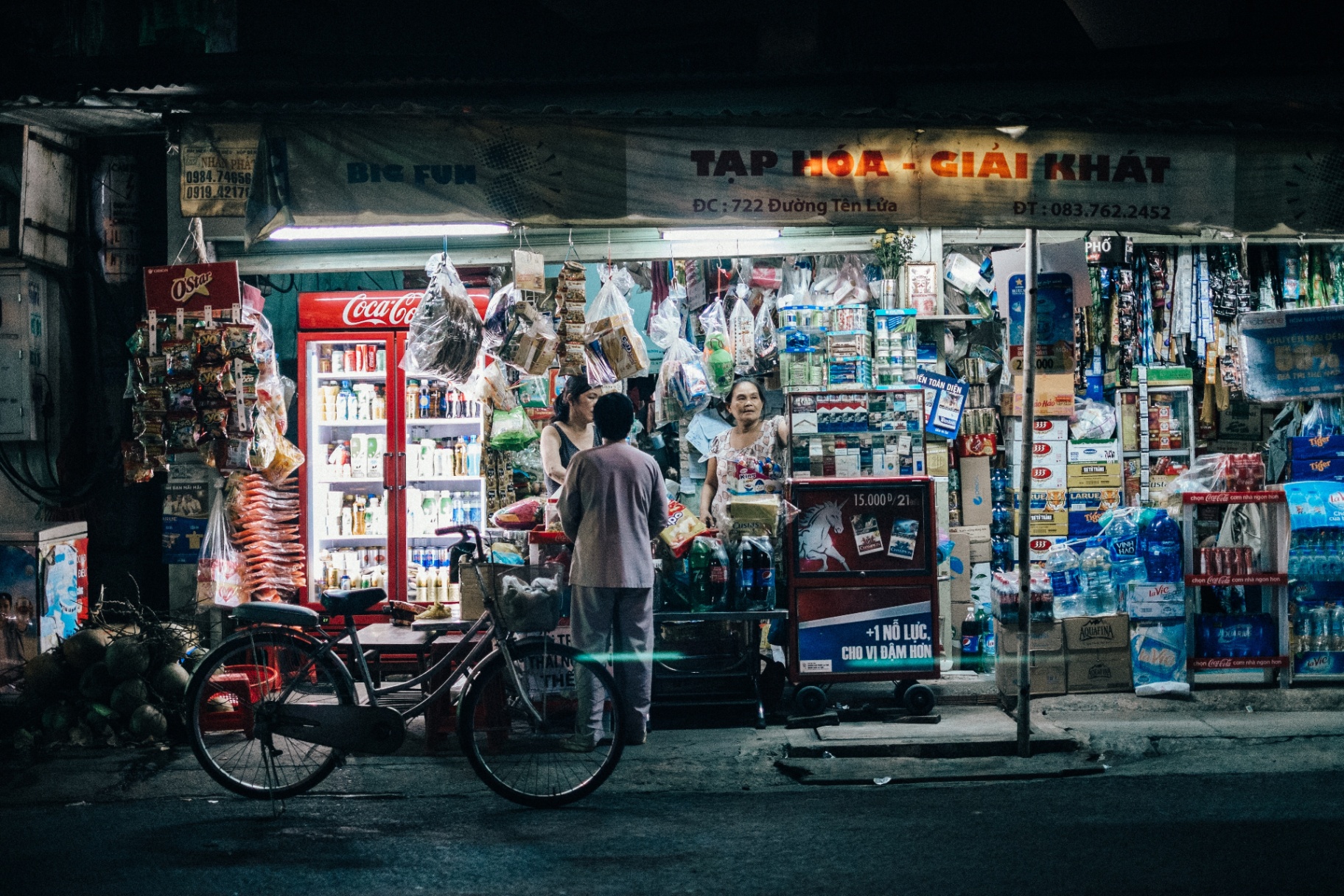 Vietnamese street-corner shop glowing at night
