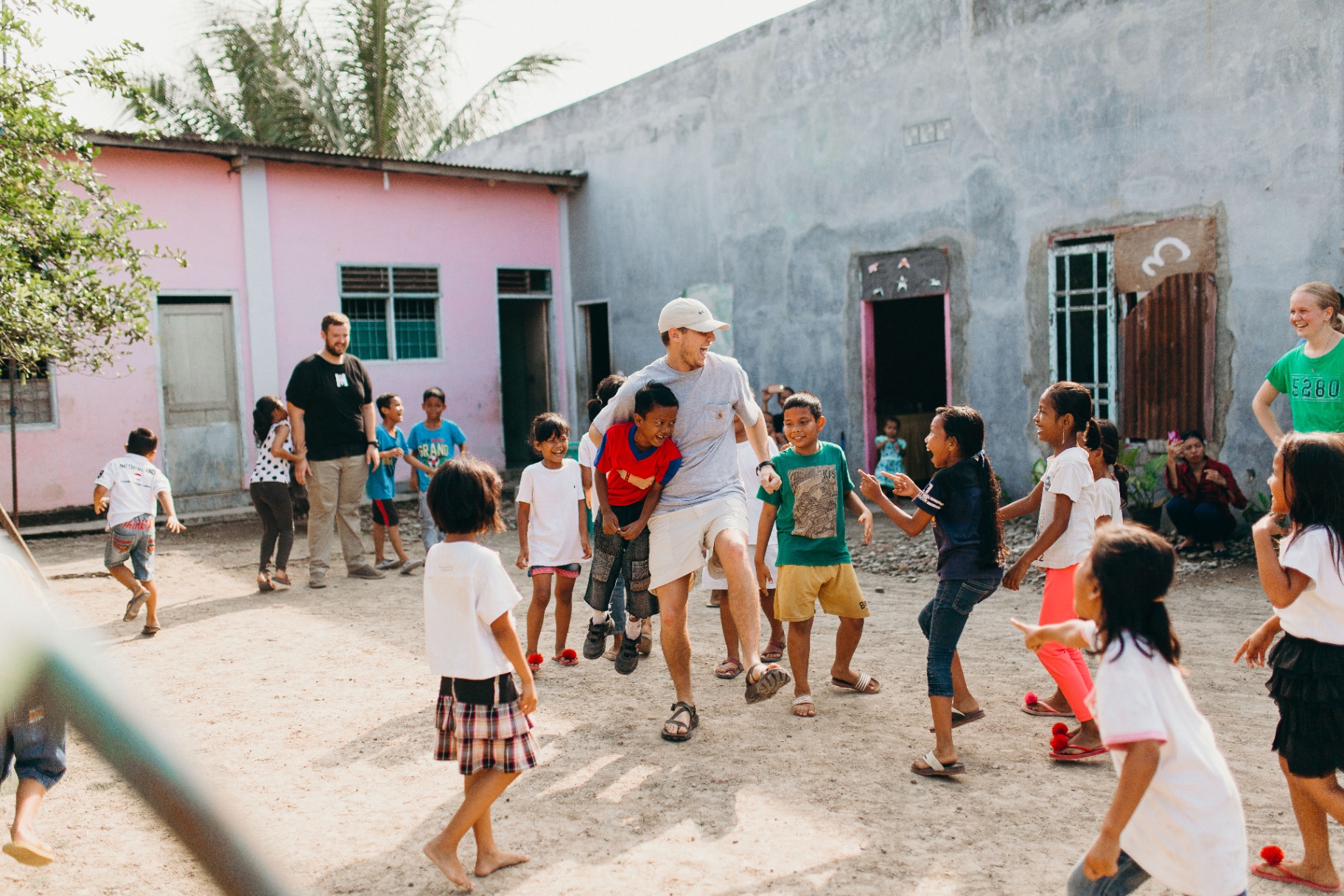 Squad member dancing with kids in an Indonesian village