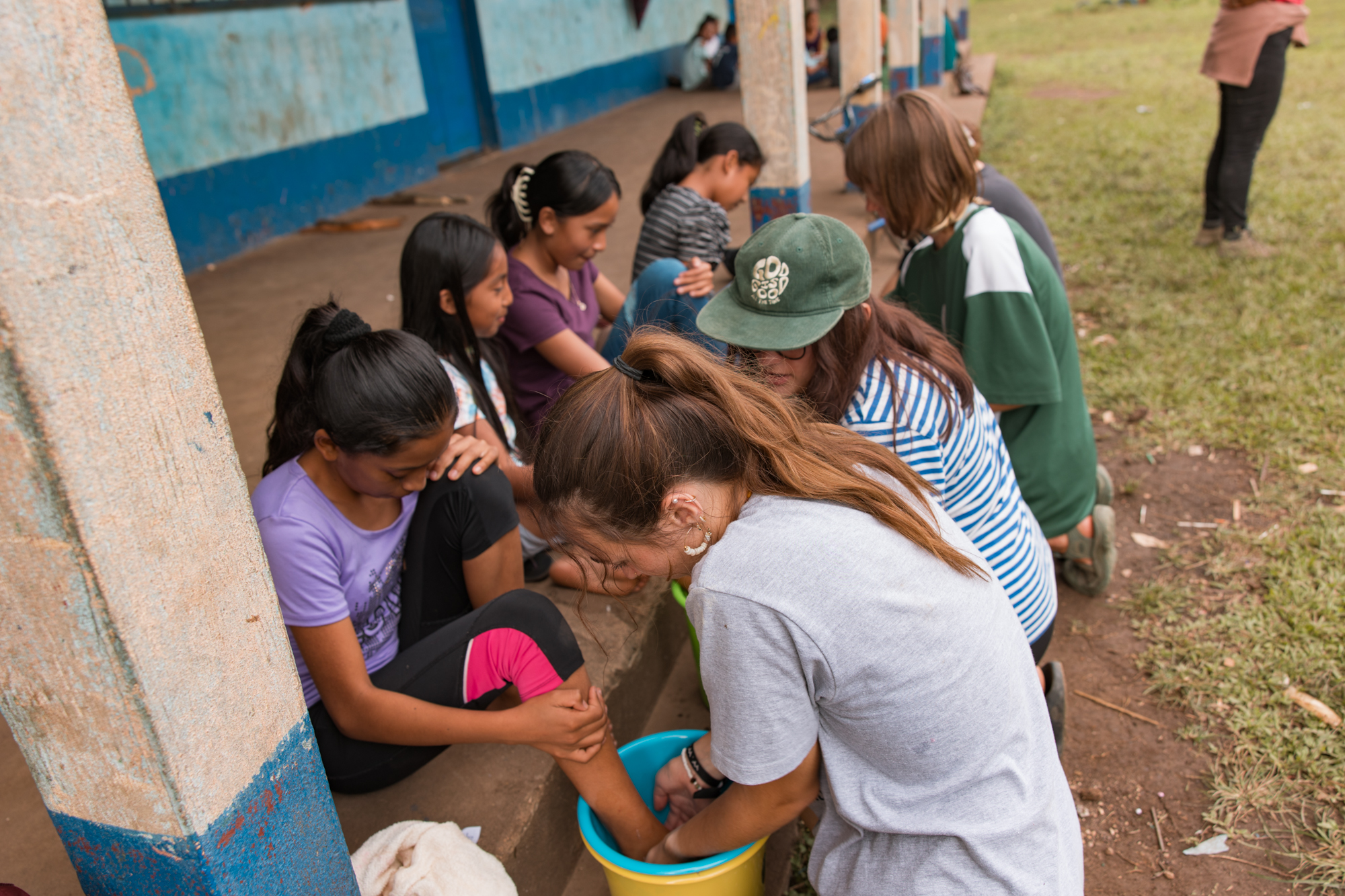 Squad members washing the feet of young girls in Guatemala