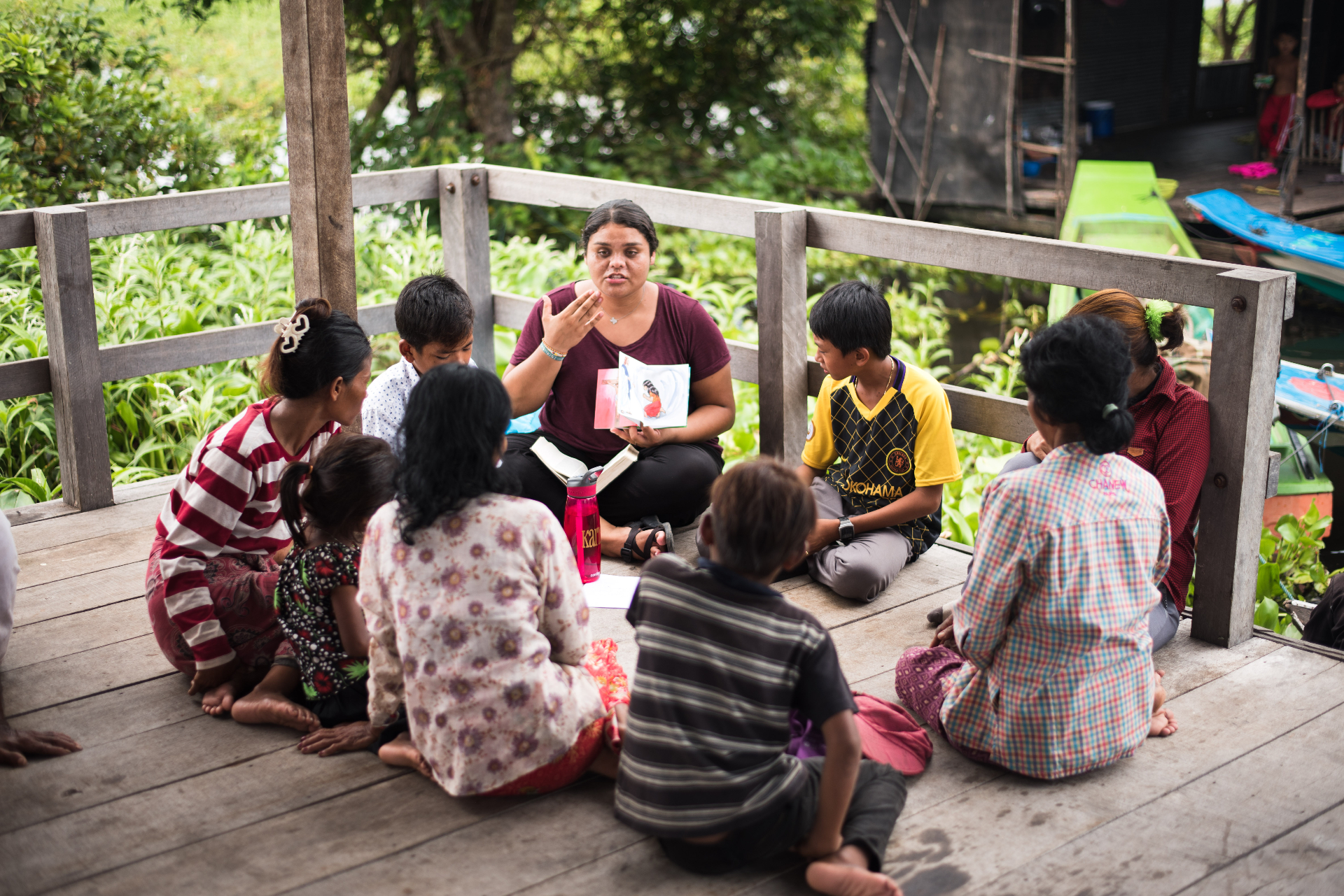 Squad member leading a small group on a wooden porch in Cambodia
