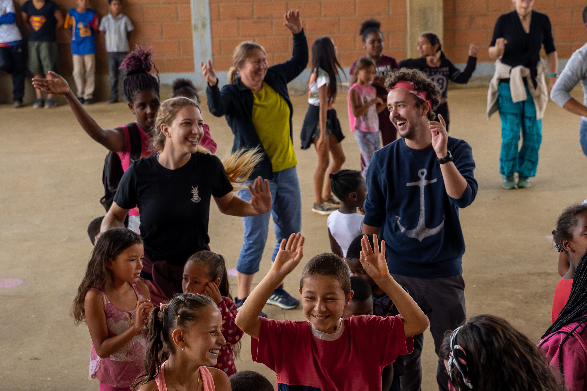 Squad members dancing with children during a Colombia ministry gathering