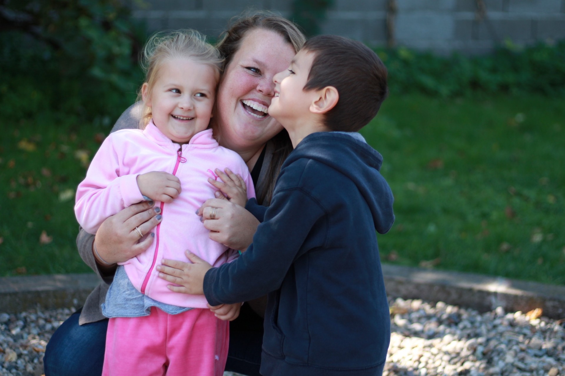 Squad member laughing with two small children in Romania