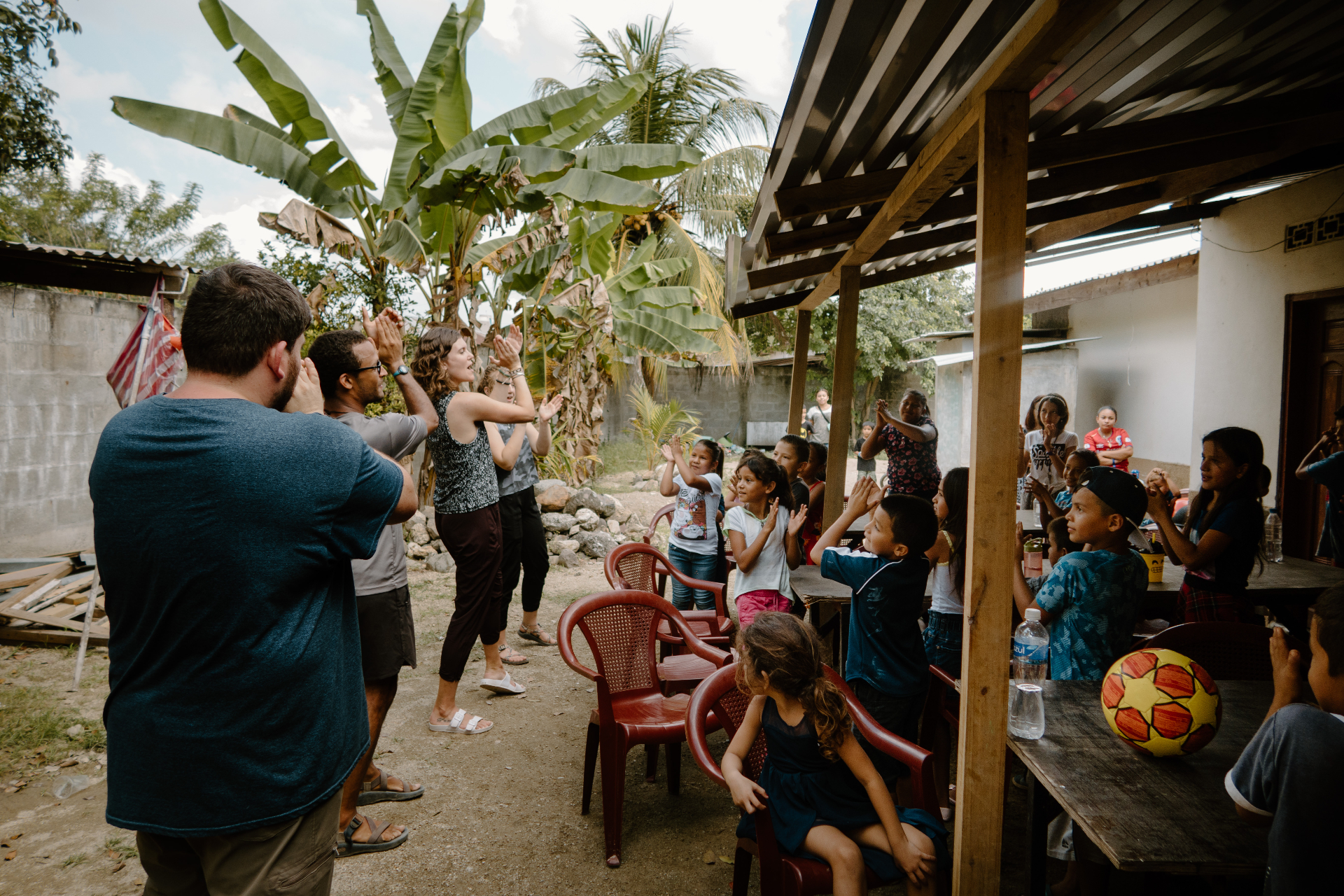 Volunteers and Honduran children clapping together