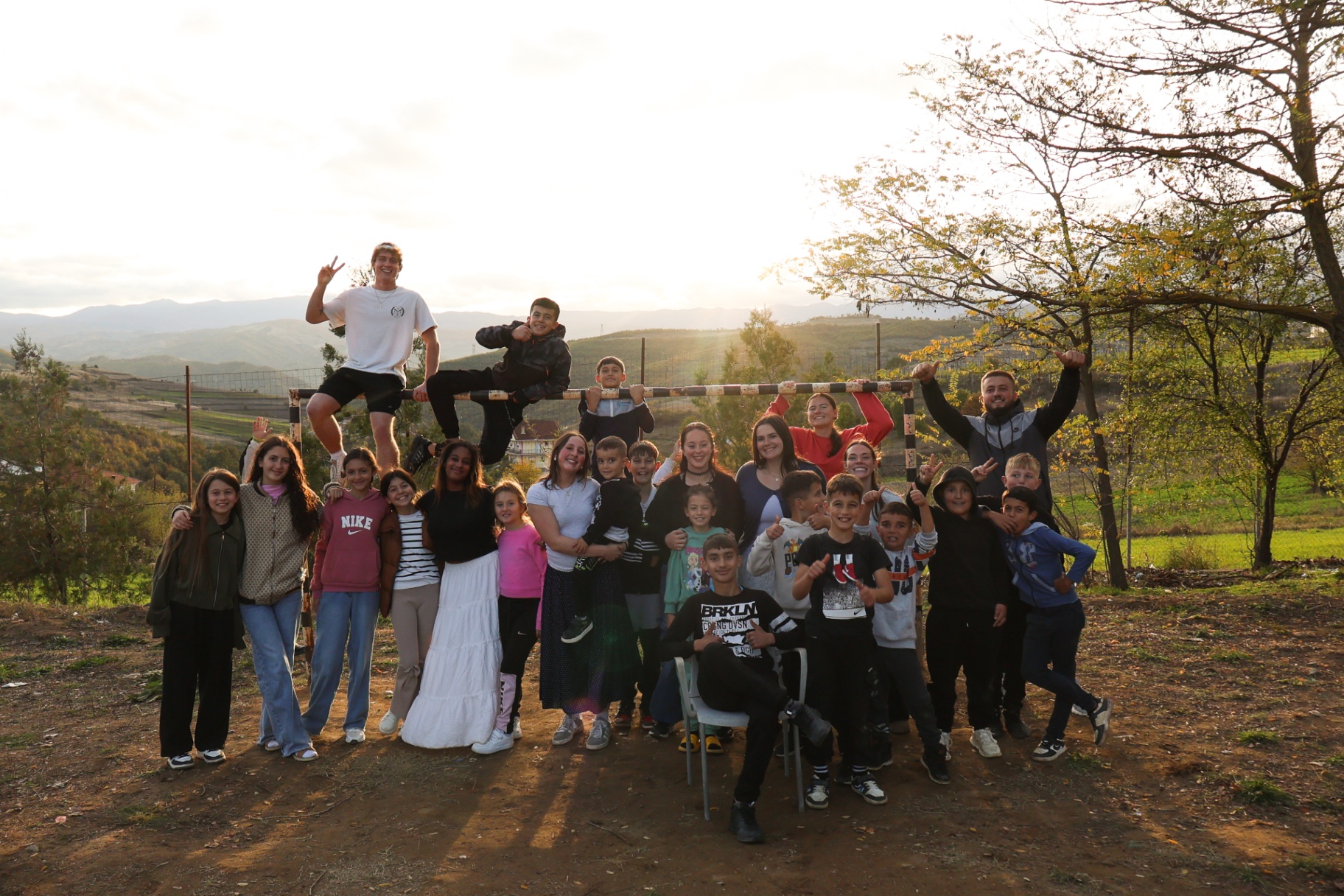 Squad and village kids gathered at golden hour in the Albanian hills