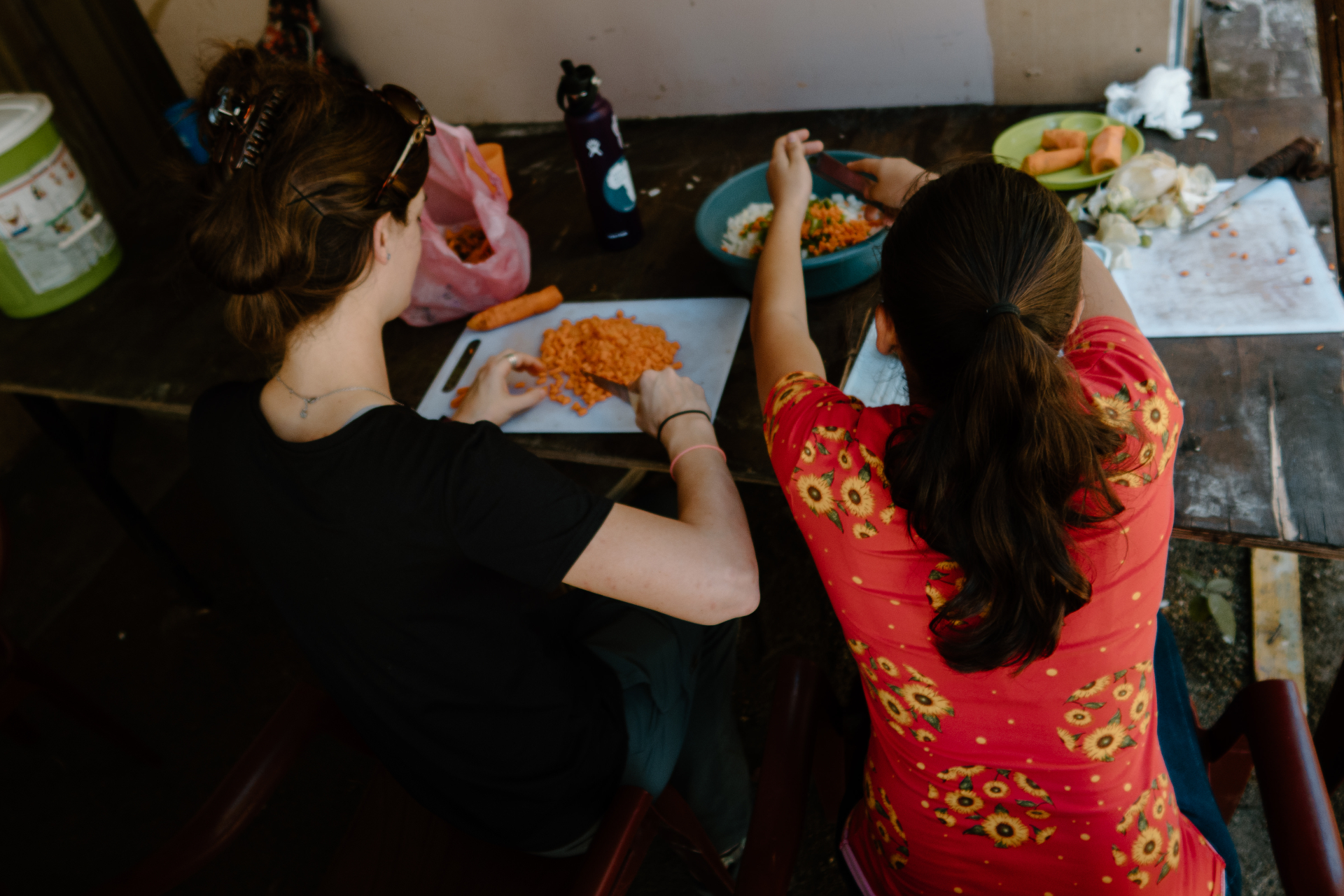 Volunteer and local woman chopping vegetables in Honduras