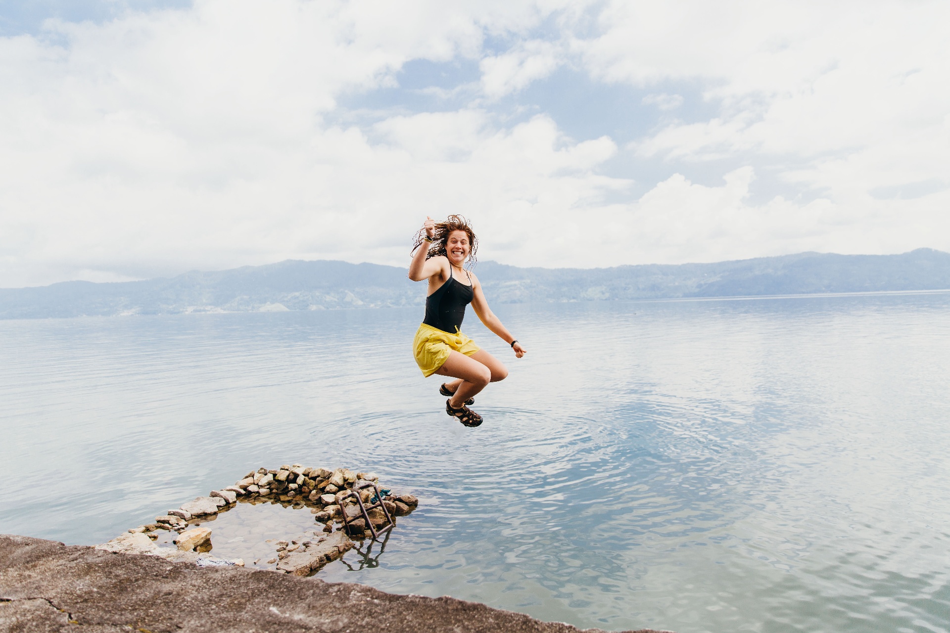 Squad member leaping into a lake on a day off in Indonesia